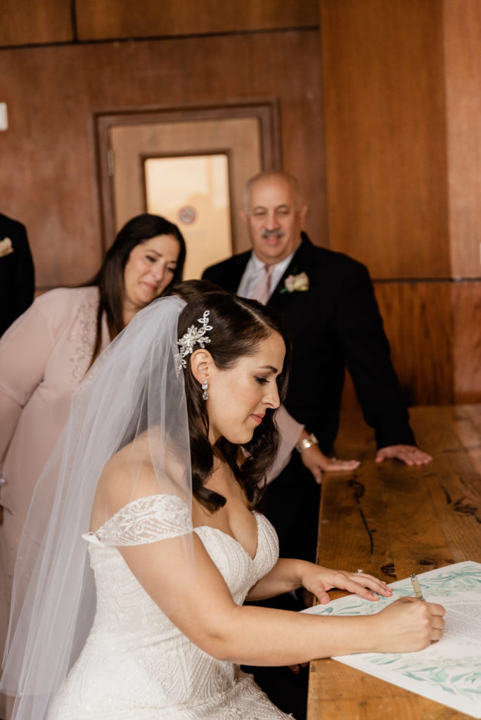 Bride signing the ketubah